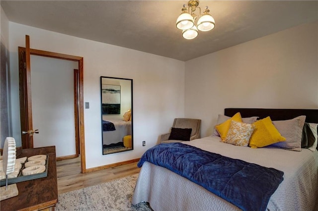 E5512 784th Ave, Menomonie, WI 54751 - bedroom with a notable chandelier, baseboards, and wood finished floors