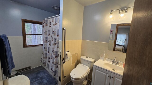 84195 State Highway 13, Bayfield, WI 54814 - full bathroom with vanity, tile walls, a shower with curtain, a wainscoted wall, and toilet