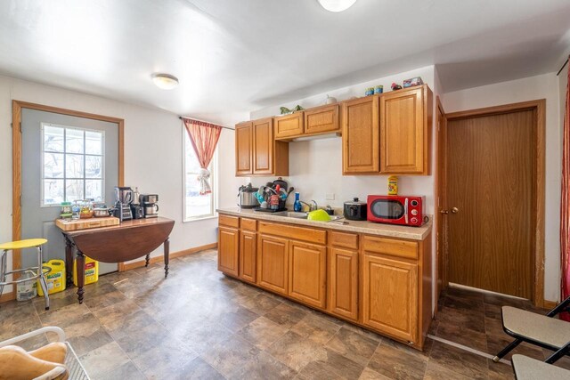 430 N 2nd Ave, Wausau, WI 54401 - kitchen featuring light countertops, a sink, brown cabinetry, and baseboards