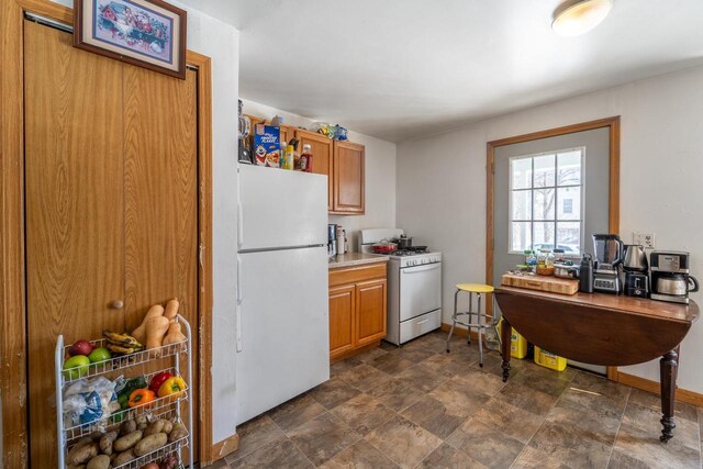 430 N 2nd Ave, Wausau, WI 54401 - kitchen with white appliances, light countertops, brown cabinets, and baseboards