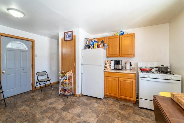 430 N 2nd Ave, Wausau, WI 54401 - kitchen featuring light countertops, stone finish flooring, baseboards, white appliances, and brown cabinetry