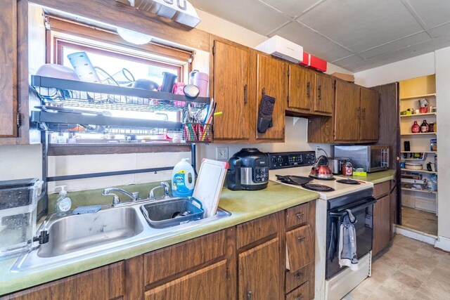 516 Hamilton St, Wausau, WI 54403 - kitchen with light countertops, a sink, brown cabinets, range with electric stovetop, and stainless steel microwave