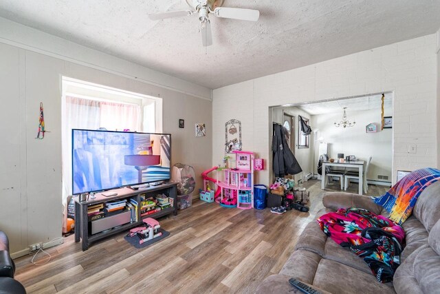 516 Hamilton St, Wausau, WI 54403 - game room featuring ceiling fan with notable chandelier, a textured ceiling, and wood finished floors