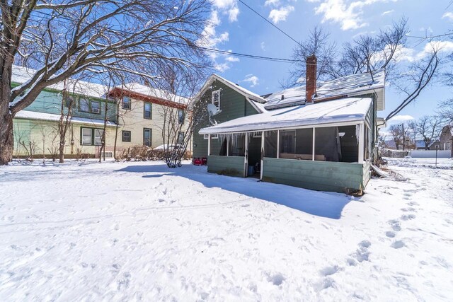 516 Hamilton St, Wausau, WI 54403 - snow covered back of property featuring a sunroom and a chimney