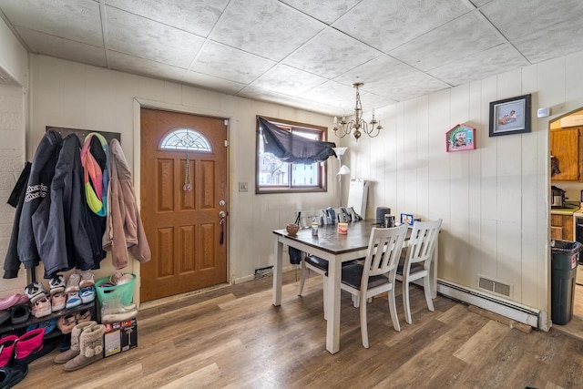 516 Hamilton St, Wausau, WI 54403 - dining space with a baseboard radiator, visible vents, wood finished floors, and a chandelier
