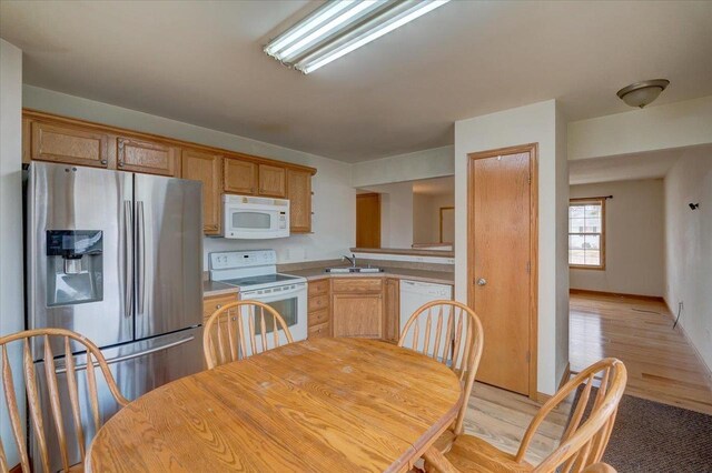 968 Pine St, Sun Prairie, WI 53590 - kitchen featuring light wood finished floors, a sink, light countertops, and white appliances