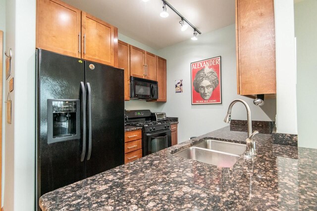 1550 E Royall Pl Unit 410, Milwaukee, WI 53202 - kitchen with dark stone countertops, a sink, a peninsula, black appliances, and brown cabinetry