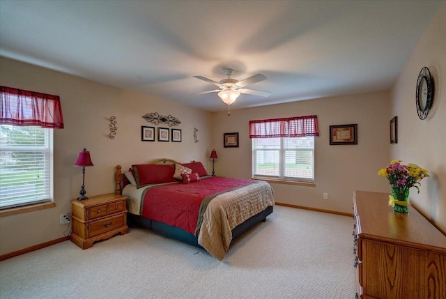 bedroom featuring baseboards, multiple windows, and light colored carpet