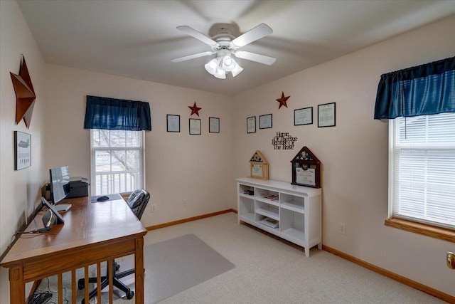 home office with baseboards, a ceiling fan, and light colored carpet