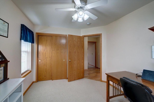 home office with ceiling fan, light colored carpet, and baseboards