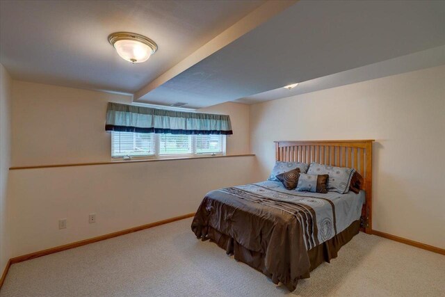 bedroom featuring baseboards, carpet flooring, and beam ceiling