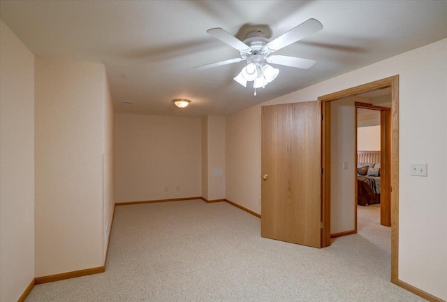 spare room with carpet floors, ceiling fan, and baseboards