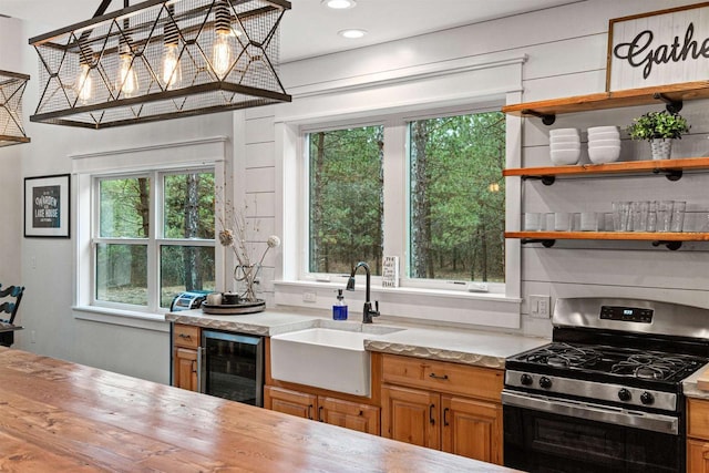 W5430 Southview Dr, Necedah, WI 54646 - kitchen featuring open shelves, a sink, brown cabinetry, stainless steel gas range, and wine cooler