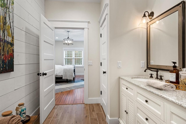W5430 Southview Dr, Necedah, WI 54646 - bathroom with baseboards, an inviting chandelier, wood finished floors, vanity, and connected bathroom
