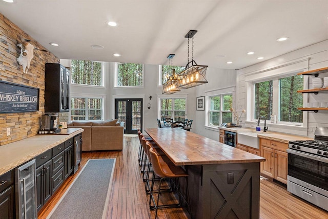 W5430 Southview Dr, Necedah, WI 54646 - kitchen featuring stainless steel range with gas stovetop, french doors, a sink, wine cooler, and wood counters