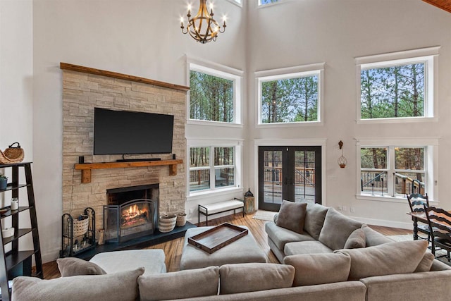 W5430 Southview Dr, Necedah, WI 54646 - living area with a towering ceiling, an inviting chandelier, a stone fireplace, wood finished floors, and french doors