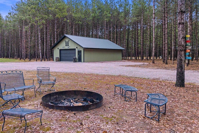 W5430 Southview Dr, Necedah, WI 54646 - exterior space with a wooded view, an outdoor fire pit, an outbuilding, and a detached garage
