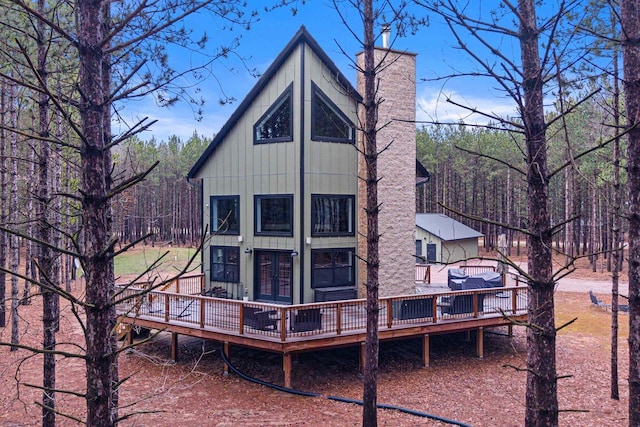 W5430 Southview Dr, Necedah, WI 54646 - back of property with a wooded view, a wooden deck, board and batten siding, and french doors