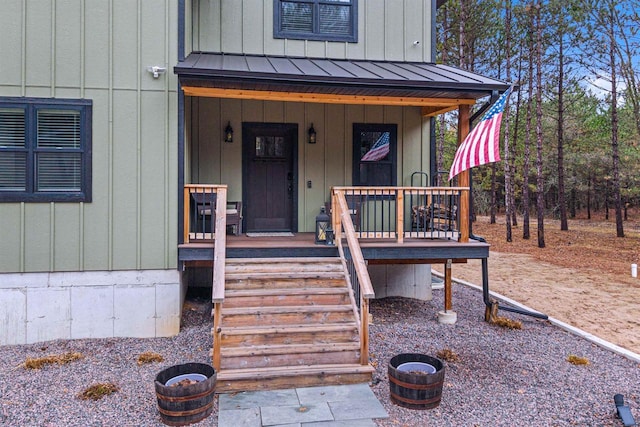 W5430 Southview Dr, Necedah, WI 54646 - view of exterior entry with board and batten siding, a porch, a standing seam roof, and metal roof