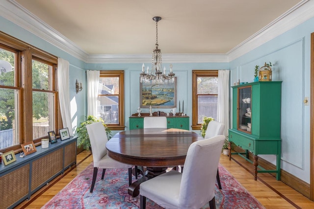 1337 Washington Ave, Oshkosh, WI 54901 - dining area with light wood-style flooring, ornamental molding, and an inviting chandelier