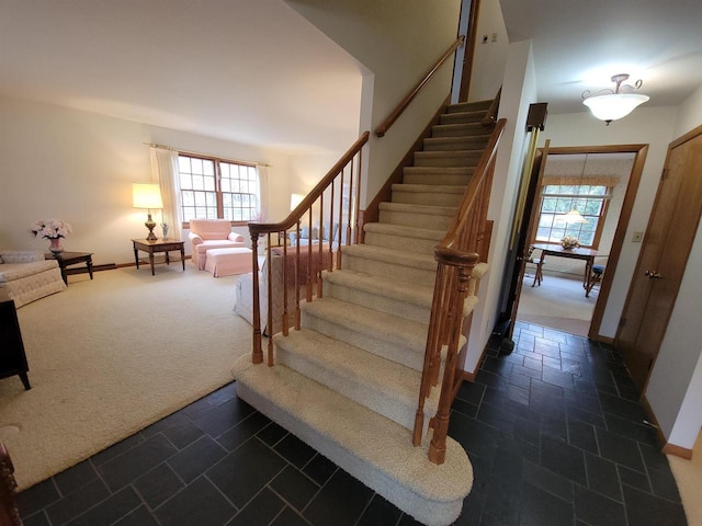 302 Riverview Ct, Portage, WI 53901 - stairs with baseboards, carpet, a healthy amount of sunlight, and stone tile flooring