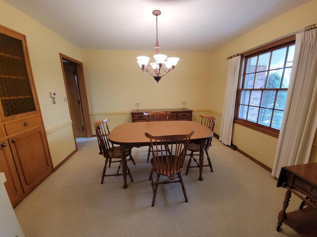 302 Riverview Ct, Portage, WI 53901 - dining space with an inviting chandelier, light carpet, and baseboards