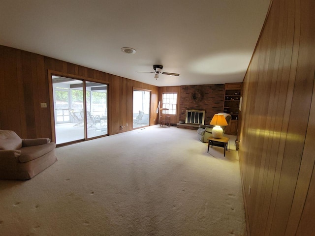 302 Riverview Ct, Portage, WI 53901 - unfurnished living room featuring carpet floors, a fireplace, wooden walls, and a ceiling fan