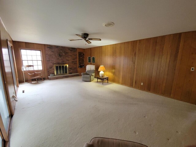 302 Riverview Ct, Portage, WI 53901 - living area with a fireplace, wood walls, ceiling fan, and carpet