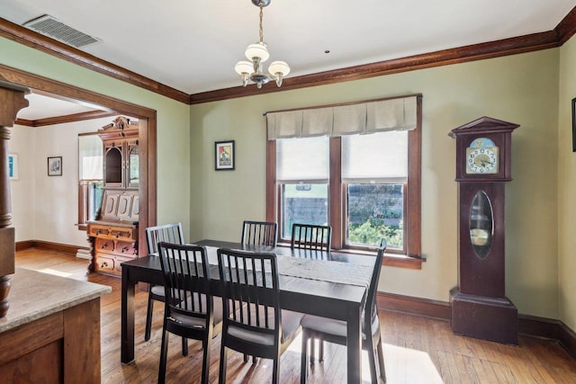 308 Forest St, Mount Horeb, WI 53572 - dining area featuring a chandelier, crown molding, plenty of natural light, baseboards, and light wood-style floors