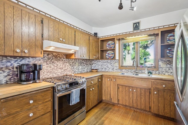 308 Forest St, Mount Horeb, WI 53572 - kitchen featuring appliances with stainless steel finishes, under cabinet range hood, a sink, open shelves, and brown cabinets