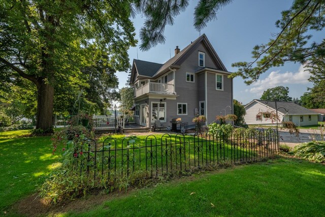 3720 County Highway Nn, West Bend, WI 53095 - back of property with a chimney, a balcony, fence, and a lawn