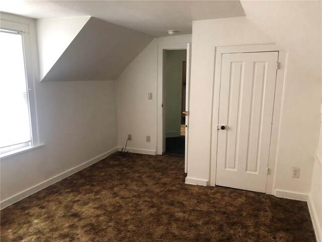609 S Dewey St, Eau Claire, WI 54701 - additional living space featuring baseboards, dark carpet, and lofted ceiling
