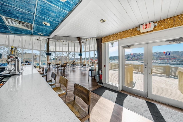 dining area featuring wooden ceiling, floor to ceiling windows, a wealth of natural light, and wood finished floors