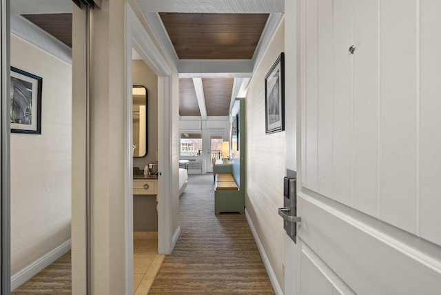 hallway with wood ceiling, carpet floors, and baseboards