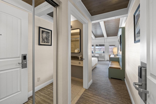 hallway featuring wooden ceiling and baseboards
