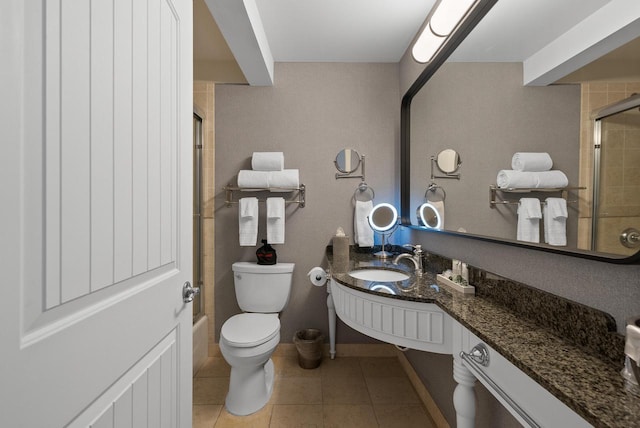 bathroom featuring toilet, a shower with shower door, tile patterned flooring, and vanity