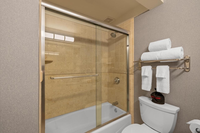 bathroom with toilet, visible vents, and bath / shower combo with glass door