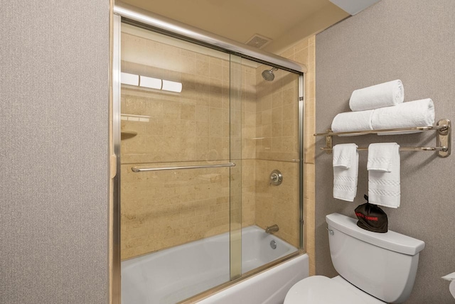 full bath with visible vents, toilet, and shower / bath combination with glass door
