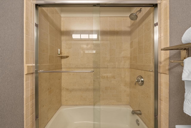 bathroom featuring bath / shower combo with glass door