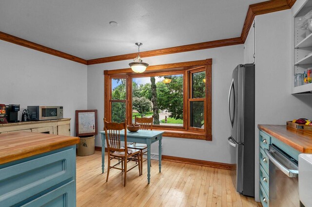 2346 Hickory Ln, Oshkosh, WI 54901 - dining area featuring baseboards, crown molding, and light wood finished floors