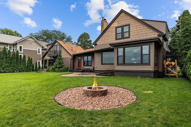 2346 Hickory Ln, Oshkosh, WI 54901 - back of property featuring a chimney, entry steps, a patio area, a fire pit, and a lawn