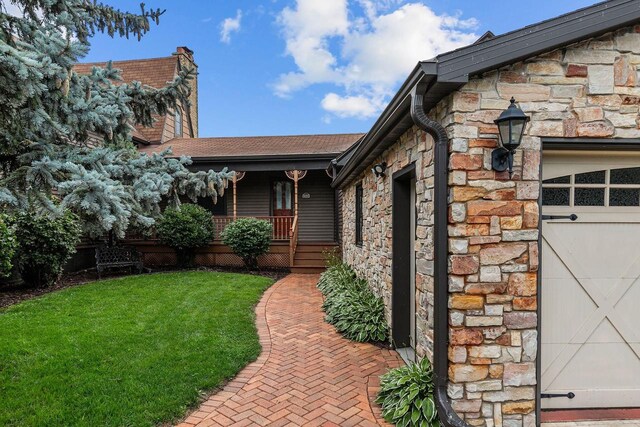 2346 Hickory Ln, Oshkosh, WI 54901 - view of property exterior featuring stone siding, a chimney, a shingled roof, a porch, and a yard