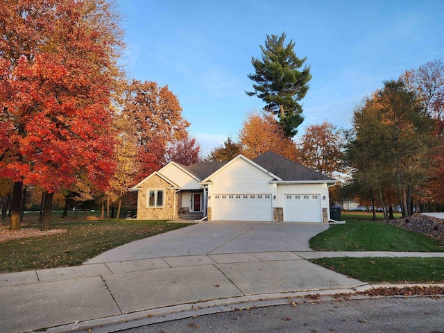 1579 Foxfire Ct, Waupaca, WI 54981 - ranch-style home featuring a front yard, an attached garage, stone siding, and driveway