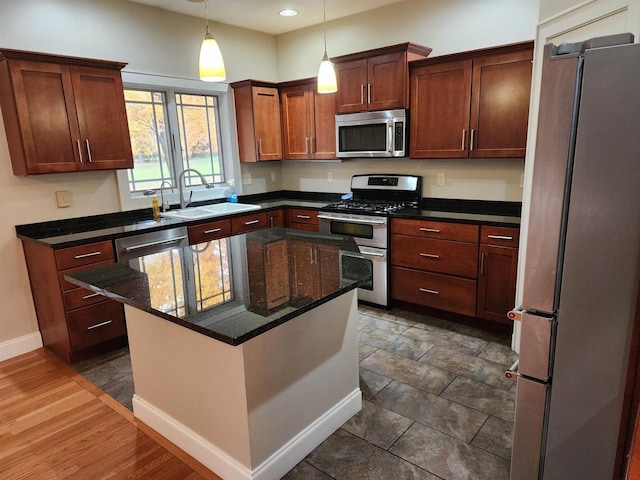 1579 Foxfire Ct, Waupaca, WI 54981 - kitchen featuring baseboards, a kitchen island, stainless steel appliances, a sink, and hanging light fixtures
