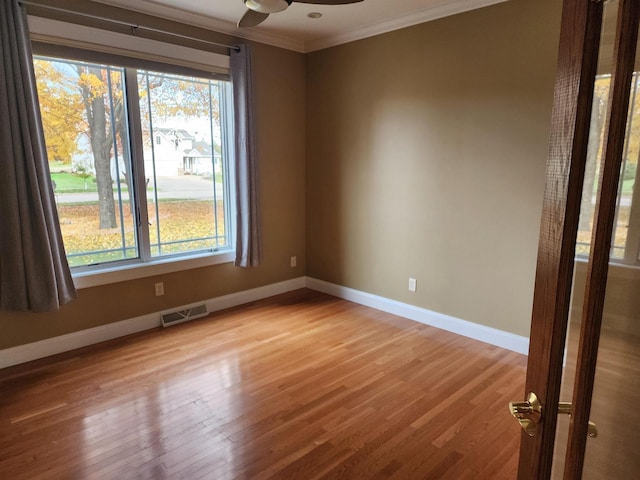 1579 Foxfire Ct, Waupaca, WI 54981 - empty room with visible vents, baseboards, ornamental molding, ceiling fan, and wood finished floors
