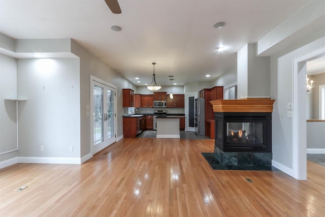 1579 Foxfire Ct, Waupaca, WI 54981 - unfurnished living room featuring light wood-style floors, a multi sided fireplace, recessed lighting, a sink, and baseboards