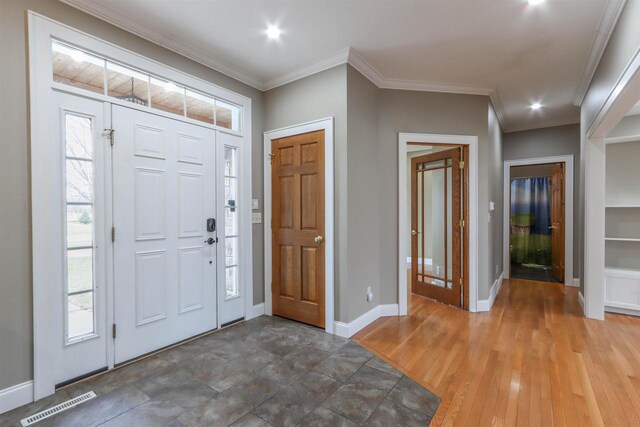 1579 Foxfire Ct, Waupaca, WI 54981 - foyer with visible vents, baseboards, crown molding, and wood finished floors
