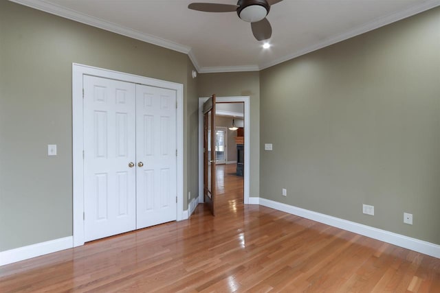 1579 Foxfire Ct, Waupaca, WI 54981 - unfurnished bedroom featuring a closet, baseboards, ornamental molding, ceiling fan, and light wood-style floors