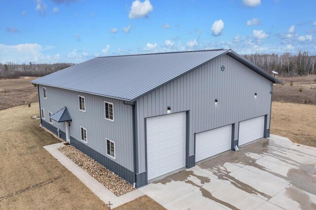 view of property exterior featuring a detached garage and metal roof