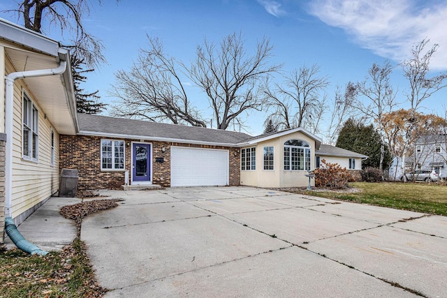view of home's exterior with driveway, roof with shingles, an attached garage, brick siding, and a yard